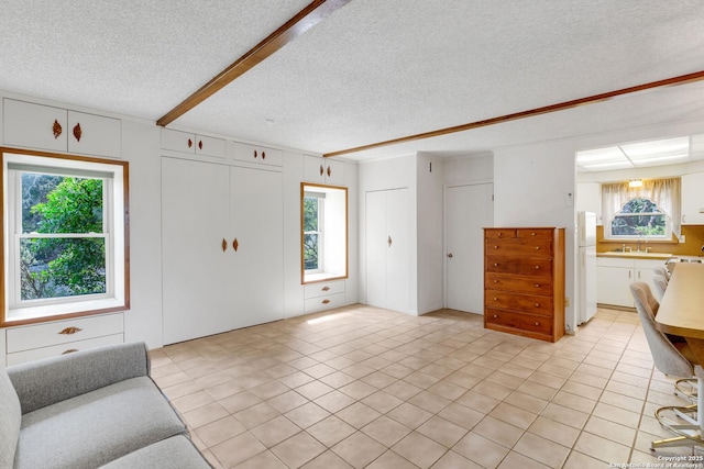 3619 Running Spgs, San Antonio, TX 78261 - unfurnished living room with a textured ceiling, a sink, healthy amount of natural light, and light tile patterned flooring