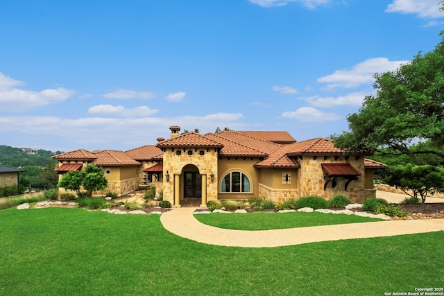 44 Oakland, Boerne, TX 78006 - mediterranean / spanish home featuring stone siding, a front lawn, stucco siding, a chimney, and a tile roof