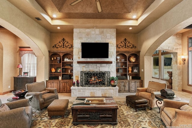 44 Oakland, Boerne, TX 78006 - living area featuring a tray ceiling, arched walkways, a stone fireplace, a towering ceiling, and recessed lighting