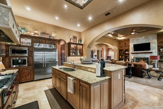 44 Oakland, Boerne, TX 78006 - kitchen featuring built in appliances, a sink, a ceiling fan, arched walkways, and an island with sink