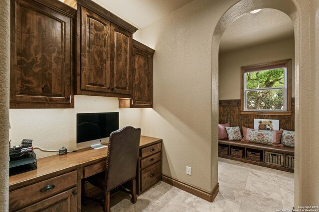 44 Oakland, Boerne, TX 78006 - home office with arched walkways, built in study area, baseboards, and a textured wall