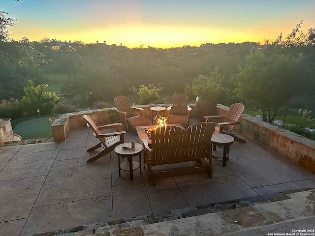44 Oakland, Boerne, TX 78006 - patio terrace at dusk featuring a fire pit, a patio area, and a putting area