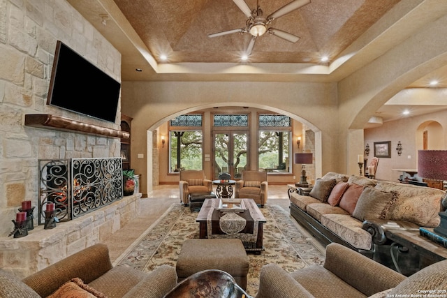 44 Oakland, Boerne, TX 78006 - living area featuring arched walkways, a towering ceiling, a ceiling fan, a fireplace, and a tray ceiling