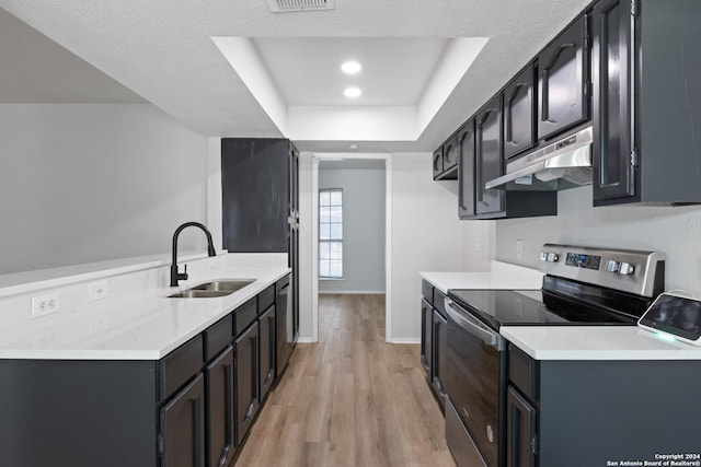 1102 Fillmore Dr, San Antonio, TX 78245 - kitchen featuring under cabinet range hood, electric range, a sink, a tray ceiling, and light wood finished floors
