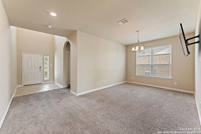 2317 Broken Wheel Ln, New Braunfels, TX 78130 - carpeted entrance foyer with arched walkways, a chandelier, a textured ceiling, and baseboards
