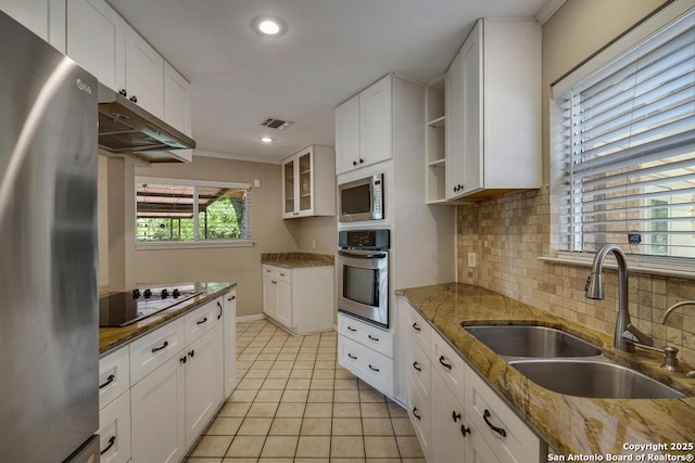 338 Tango Dr, San Antonio, TX 78216 - kitchen with stainless steel appliances, a sink, light tile patterned flooring, tasteful backsplash, and white cabinets
