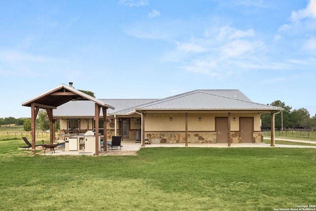 381 Schneider Rd, Seguin, TX 78155 - rear view of property featuring stone siding, a yard, metal roof, and a patio area