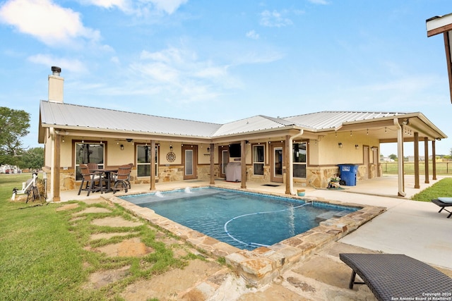 381 Schneider Rd, Seguin, TX 78155 - rear view of house with a patio, stone siding, and metal roof