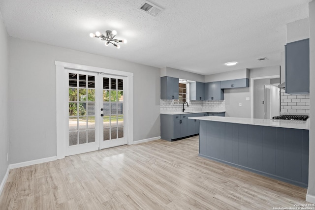 7626 Westfield, San Antonio, TX 78227 - kitchen featuring gray cabinets, a sink, a peninsula, light countertops, and decorative backsplash