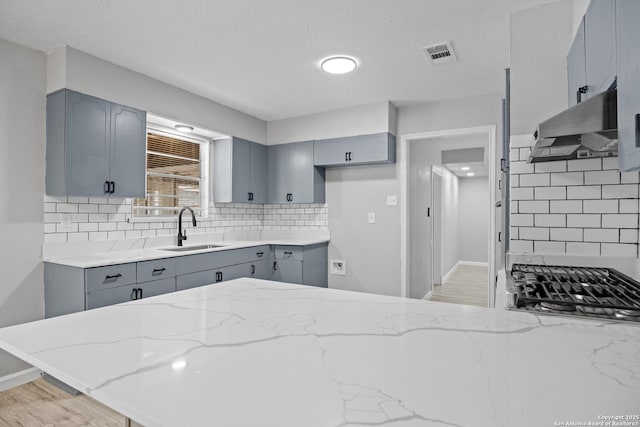 7626 Westfield, San Antonio, TX 78227 - kitchen with a sink, gray cabinets, light stone countertops, and under cabinet range hood