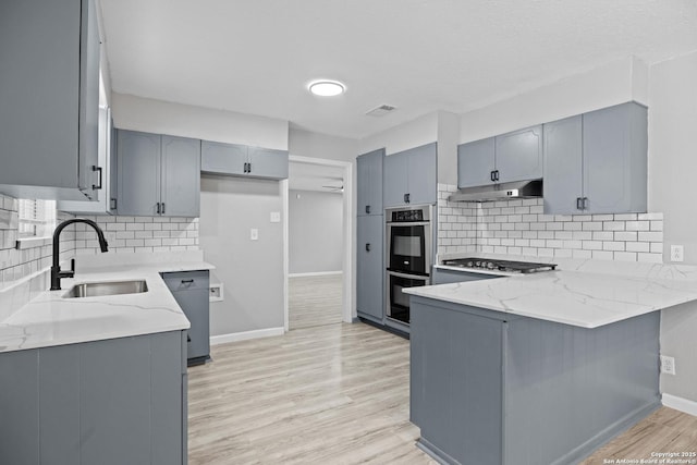 7626 Westfield, San Antonio, TX 78227 - kitchen featuring a sink, stainless steel appliances, a peninsula, and light stone countertops
