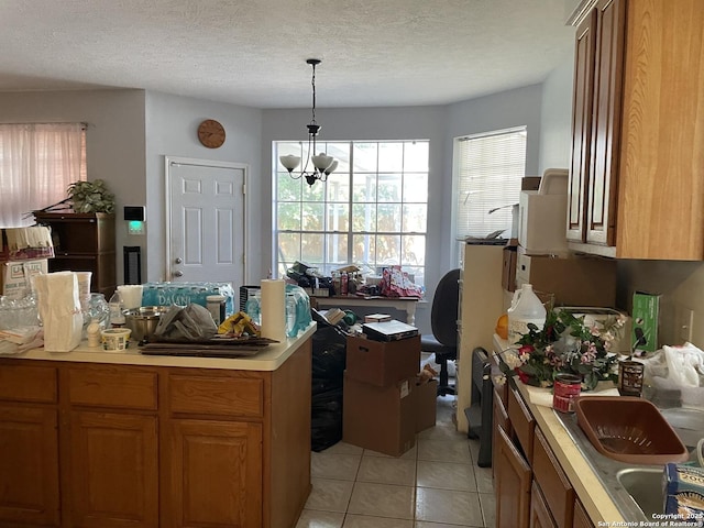 19102 Weeping Oak, Spring, TX 77388 - kitchen featuring light tile patterned floors, light countertops, brown cabinets, decorative light fixtures, and a textured ceiling