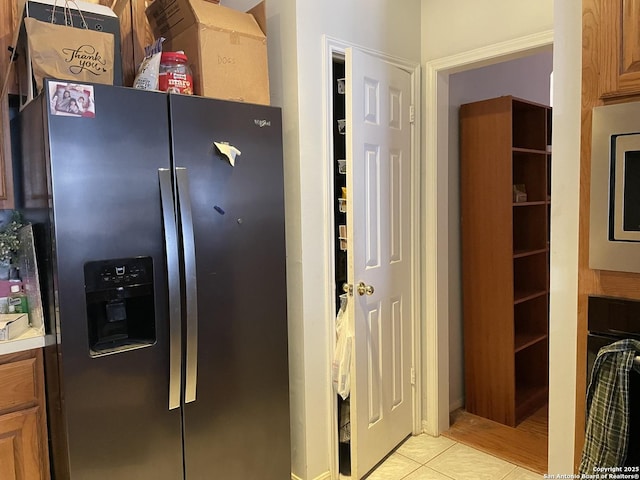 19102 Weeping Oak, Spring, TX 77388 - kitchen featuring appliances with stainless steel finishes, light tile patterned flooring, light countertops, and brown cabinetry