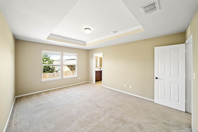 445 Auburn Park, Schertz, TX 78154 - unfurnished bedroom with light carpet, a tray ceiling, baseboards, and connected bathroom