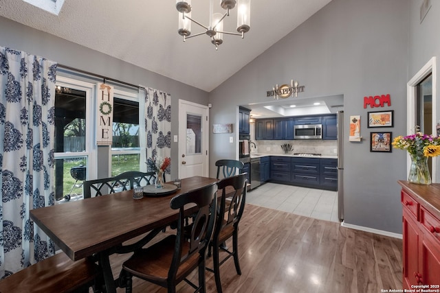 2930 Low Oak St, San Antonio, TX 78232 - dining area featuring a chandelier, light wood finished floors, baseboards, and high vaulted ceiling