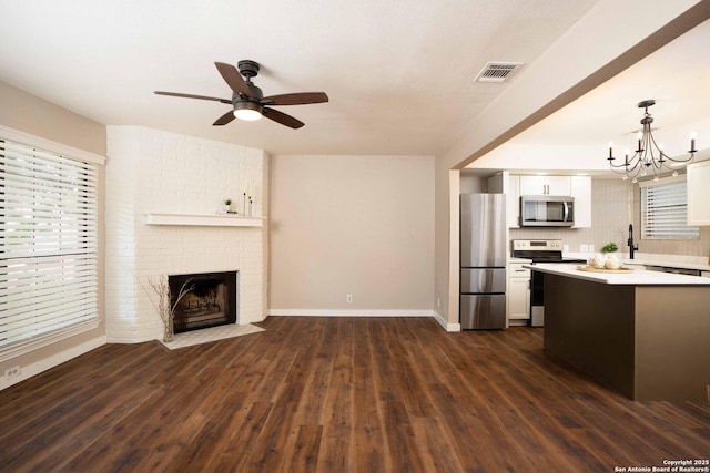 12006 Vista Nogal Unit 3A, San Antonio, TX 78213 - kitchen with stainless steel appliances, light countertops, open floor plan, white cabinets, and dark wood finished floors