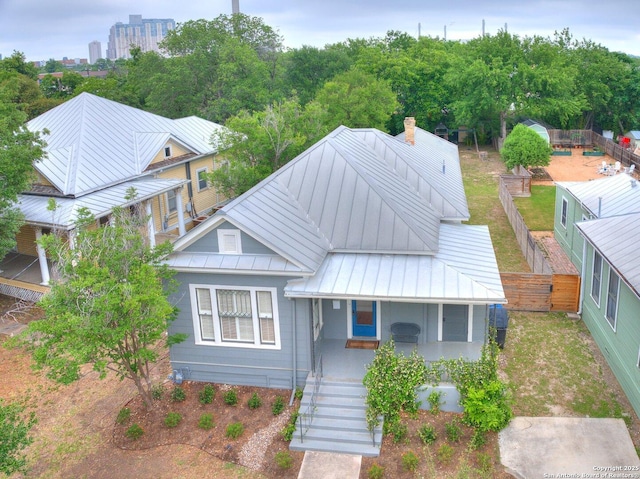 302 Cedar, San Antonio, TX 78210 - view of front of home with a standing seam roof, covered porch, a chimney, metal roof, and fence