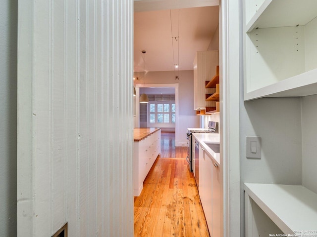302 Cedar, San Antonio, TX 78210 - kitchen featuring stainless steel range with gas stovetop, light wood-style floors, light countertops, white cabinets, and open shelves