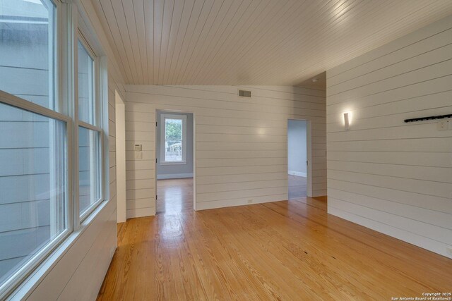 302 Cedar, San Antonio, TX 78210 - unfurnished room with wood walls and light wood-style flooring