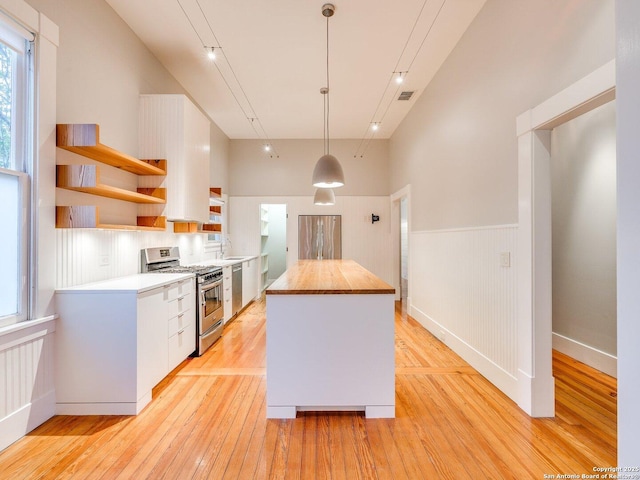 302 Cedar, San Antonio, TX 78210 - kitchen with appliances with stainless steel finishes, open shelves, wooden counters, light wood-type flooring, and wainscoting