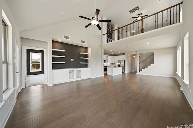 12414 Mineshaft, San Antonio, TX 78254 - unfurnished living room with ceiling fan, high vaulted ceiling, dark wood finished floors, baseboards, and stairs