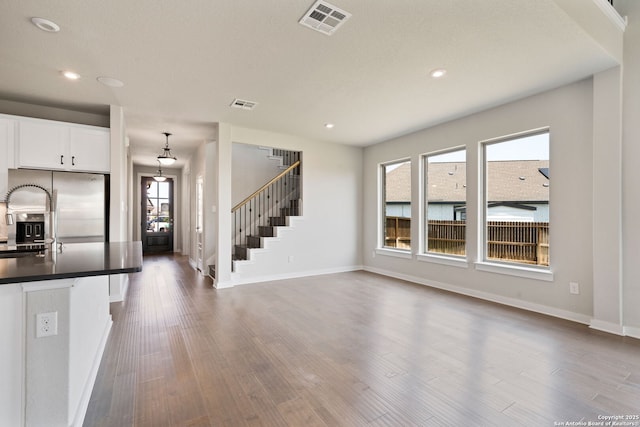 12414 Mineshaft, San Antonio, TX 78254 - unfurnished living room featuring stairs, baseboards, dark wood finished floors, and recessed lighting