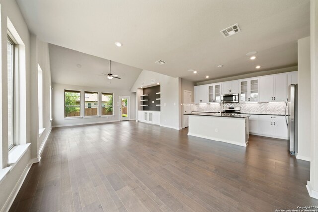 12414 Mineshaft, San Antonio, TX 78254 - unfurnished living room featuring a ceiling fan, recessed lighting, dark wood-type flooring, baseboards, and lofted ceiling