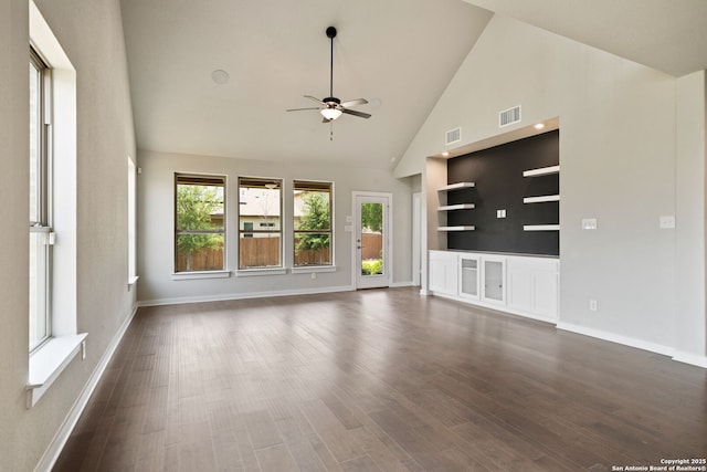 12414 Mineshaft, San Antonio, TX 78254 - unfurnished living room featuring ceiling fan, baseboards, dark wood-style flooring, high vaulted ceiling, and built in shelves
