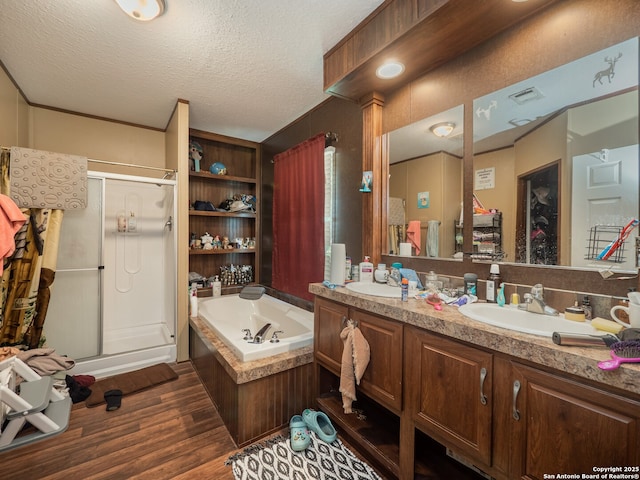 15411 Cranes Mill Rd, Canyon Lake, TX 78133 - full bath featuring a bath, a stall shower, wood finished floors, double vanity, and a textured ceiling