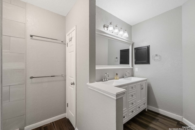 6909 Quail Lk, San Antonio, TX 78244 - full bath with wood finished floors, baseboards, and double vanity