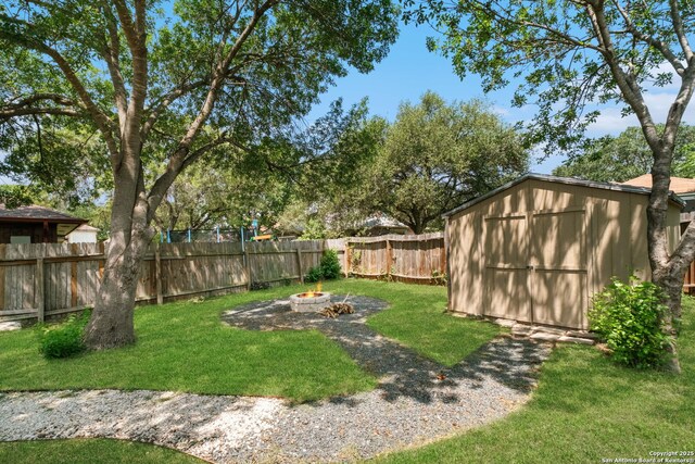 6909 Quail Lk, San Antonio, TX 78244 - view of yard with a storage shed, a fire pit, and an outbuilding