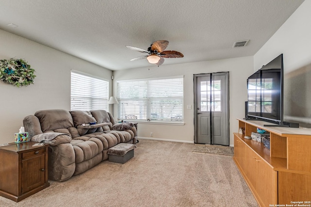 11014 Palomino, San Antonio, TX 78245 - living room featuring a ceiling fan, healthy amount of natural light, light carpet, a textured ceiling, and baseboards