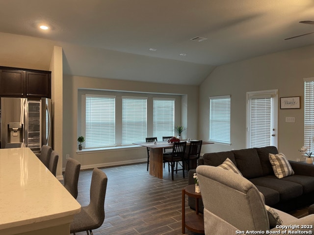 living room featuring lofted ceiling, dark wood-style flooring, a ceiling fan, recessed lighting, and baseboards