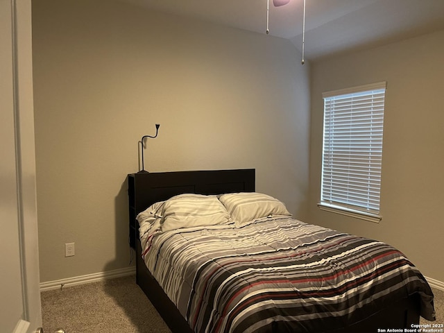 carpeted bedroom with baseboards and lofted ceiling