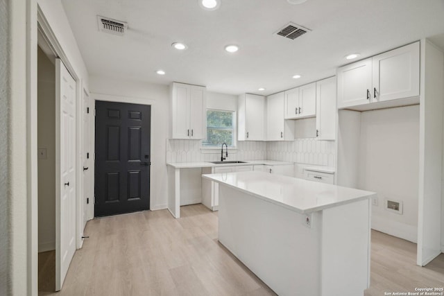 620 Euclid, San Antonio, TX 78212 - kitchen featuring light wood-style flooring, tasteful backsplash, recessed lighting, a kitchen island, and white cabinetry