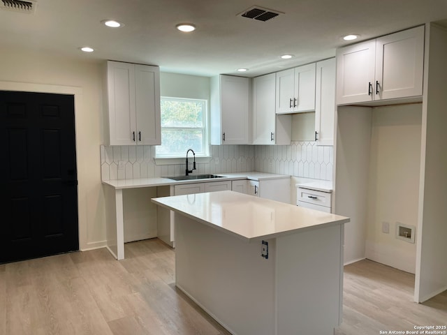 620 Euclid, San Antonio, TX 78212 - kitchen with light wood-type flooring, a center island, recessed lighting, tasteful backsplash, and white cabinets