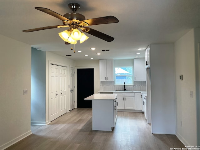 620 Euclid, San Antonio, TX 78212 - kitchen featuring light wood-style floors, a center island, decorative backsplash, light countertops, and recessed lighting