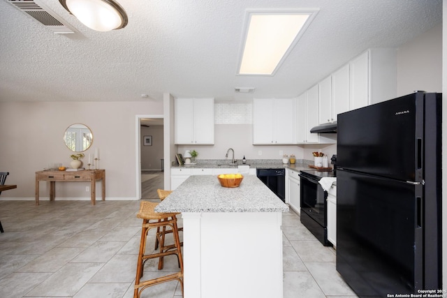 10511 Stone Crk, San Antonio, TX 78254 - kitchen featuring black appliances, under cabinet range hood, a kitchen island, a breakfast bar area, and a sink