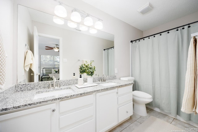 10511 Stone Crk, San Antonio, TX 78254 - full bath featuring double vanity, tile patterned floors, toilet, and a ceiling fan