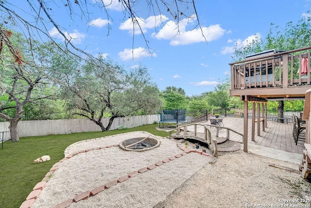 13619 Mesa Pt, San Antonio, TX 78232 - view of yard with an outdoor fire pit, a wooden deck, and a trampoline