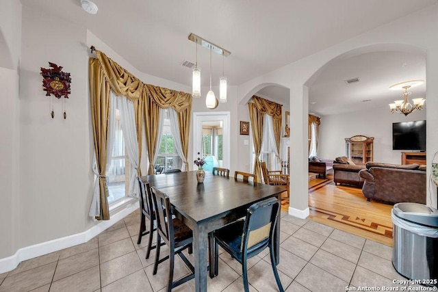 13619 Mesa Pt, San Antonio, TX 78232 - dining space with light tile patterned floors, arched walkways, baseboards, and a chandelier