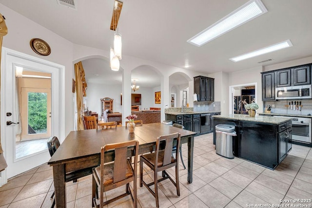 13619 Mesa Pt, San Antonio, TX 78232 - kitchen featuring stainless steel appliances, arched walkways, and dark cabinetry