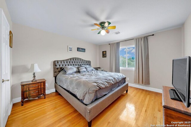 13619 Mesa Pt, San Antonio, TX 78232 - bedroom with baseboards, light wood-style floors, and a ceiling fan