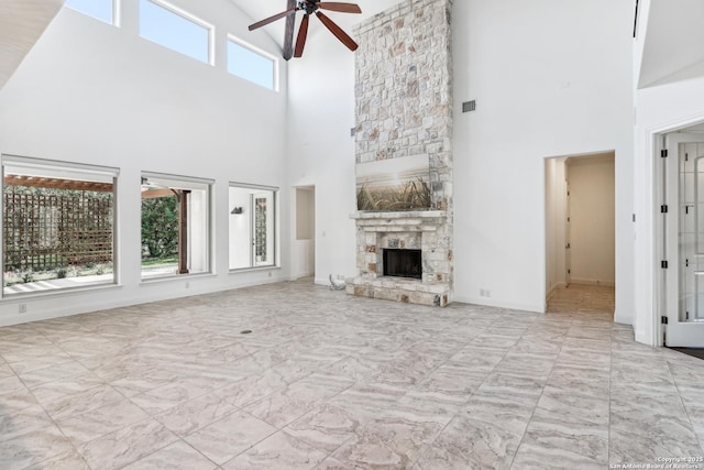 6327 Almeria Cir, San Antonio, TX 78257 - unfurnished living room with a towering ceiling, a ceiling fan, a fireplace, and baseboards