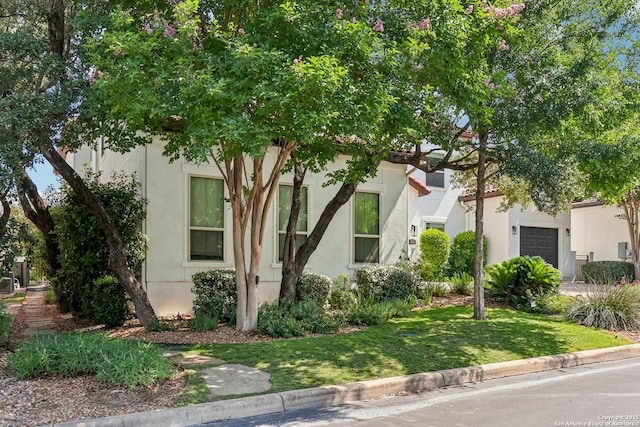 6327 Almeria Cir, San Antonio, TX 78257 - view of front of home featuring stucco siding, a front yard, and an attached garage