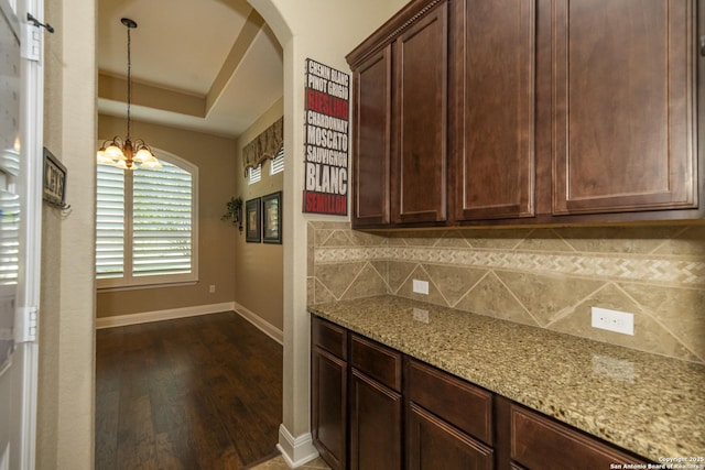 3308 Ashleys, Marion, TX 78124 - kitchen with dark wood-style floors, baseboards, light stone counters, tasteful backsplash, and arched walkways