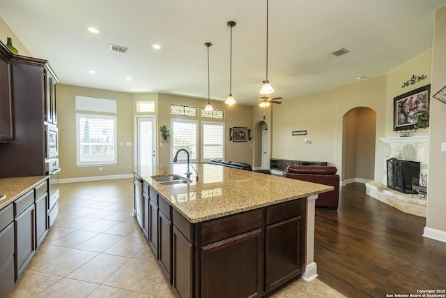 3308 Ashleys, Marion, TX 78124 - kitchen with a sink, arched walkways, appliances with stainless steel finishes, a high end fireplace, and dark brown cabinets