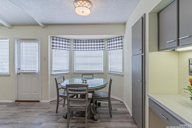 5718 Ponderosa Dr, San Antonio, TX 78240 - dining area featuring wood finished floors, a textured ceiling, beamed ceiling, and baseboards