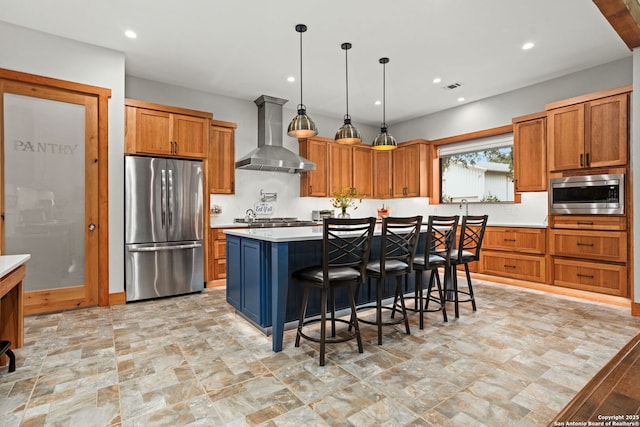 1133 Horseshoe Fls, Bandera, TX 78003 - kitchen with appliances with stainless steel finishes, wall chimney exhaust hood, light countertops, a center island, and brown cabinetry