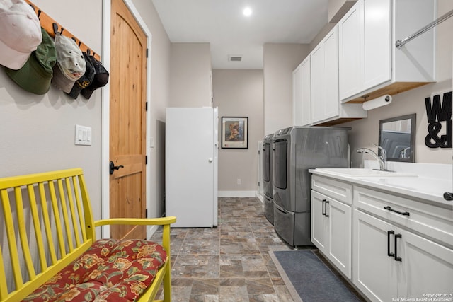1133 Horseshoe Fls, Bandera, TX 78003 - washroom featuring washer and clothes dryer, stone finish floors, cabinet space, and baseboards